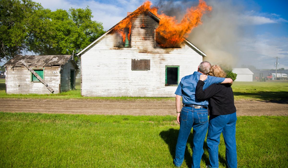 couple looking at house fire damage