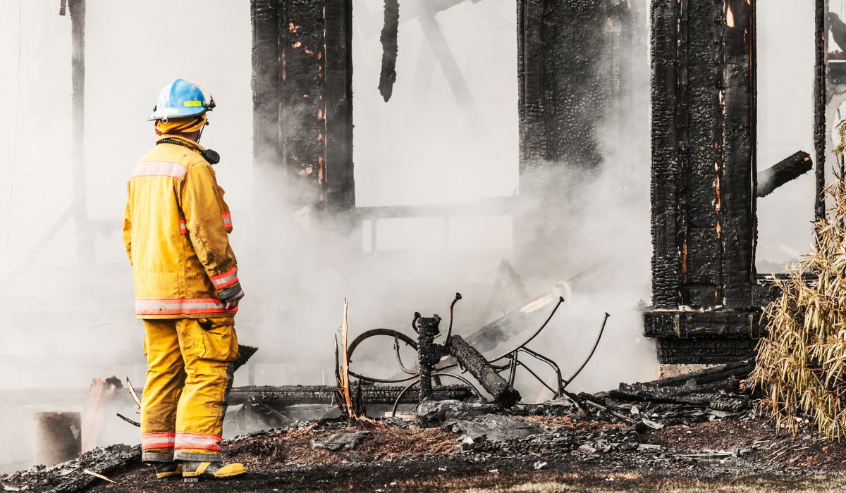 person inspecting fire on house