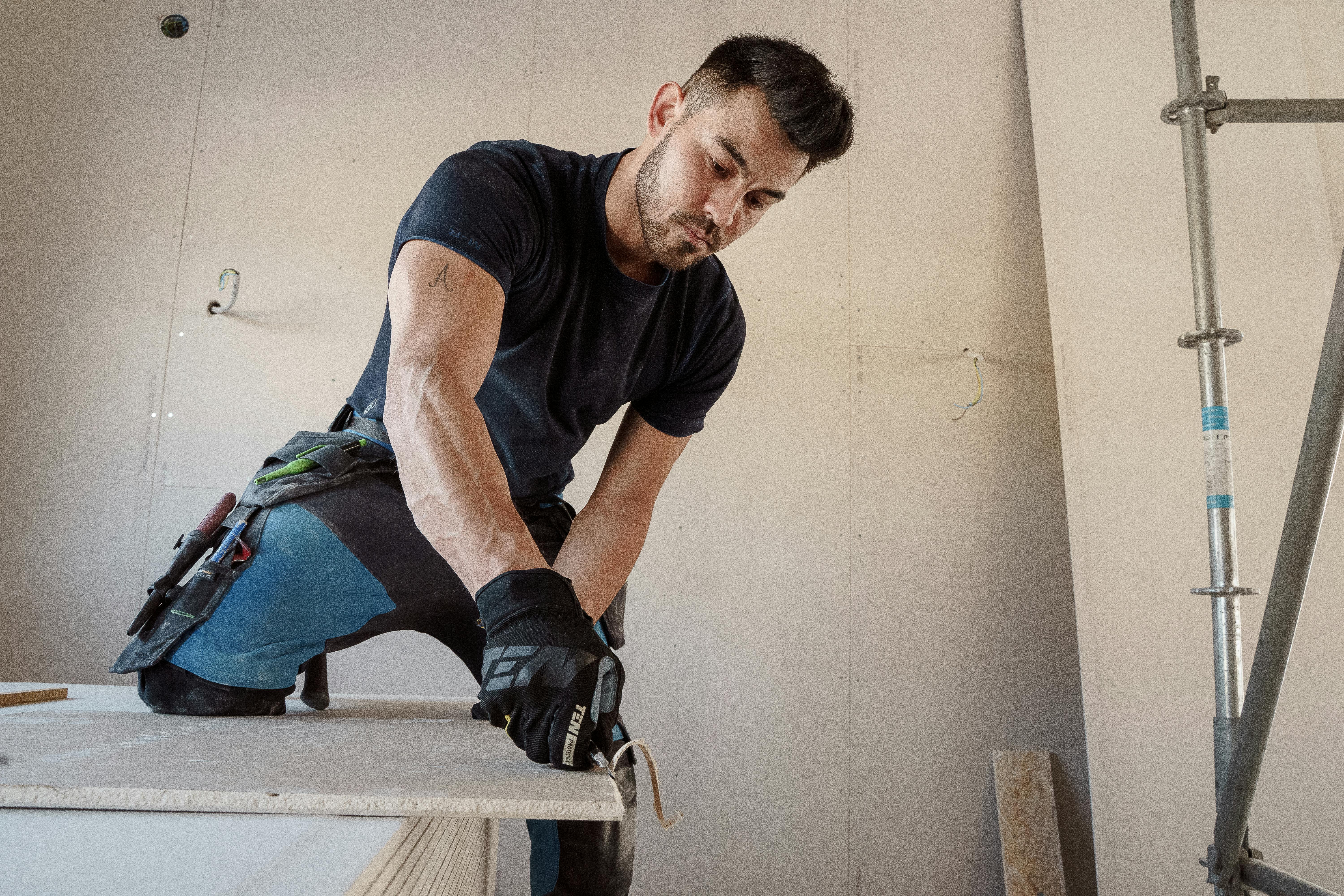 person working and cutting drywall