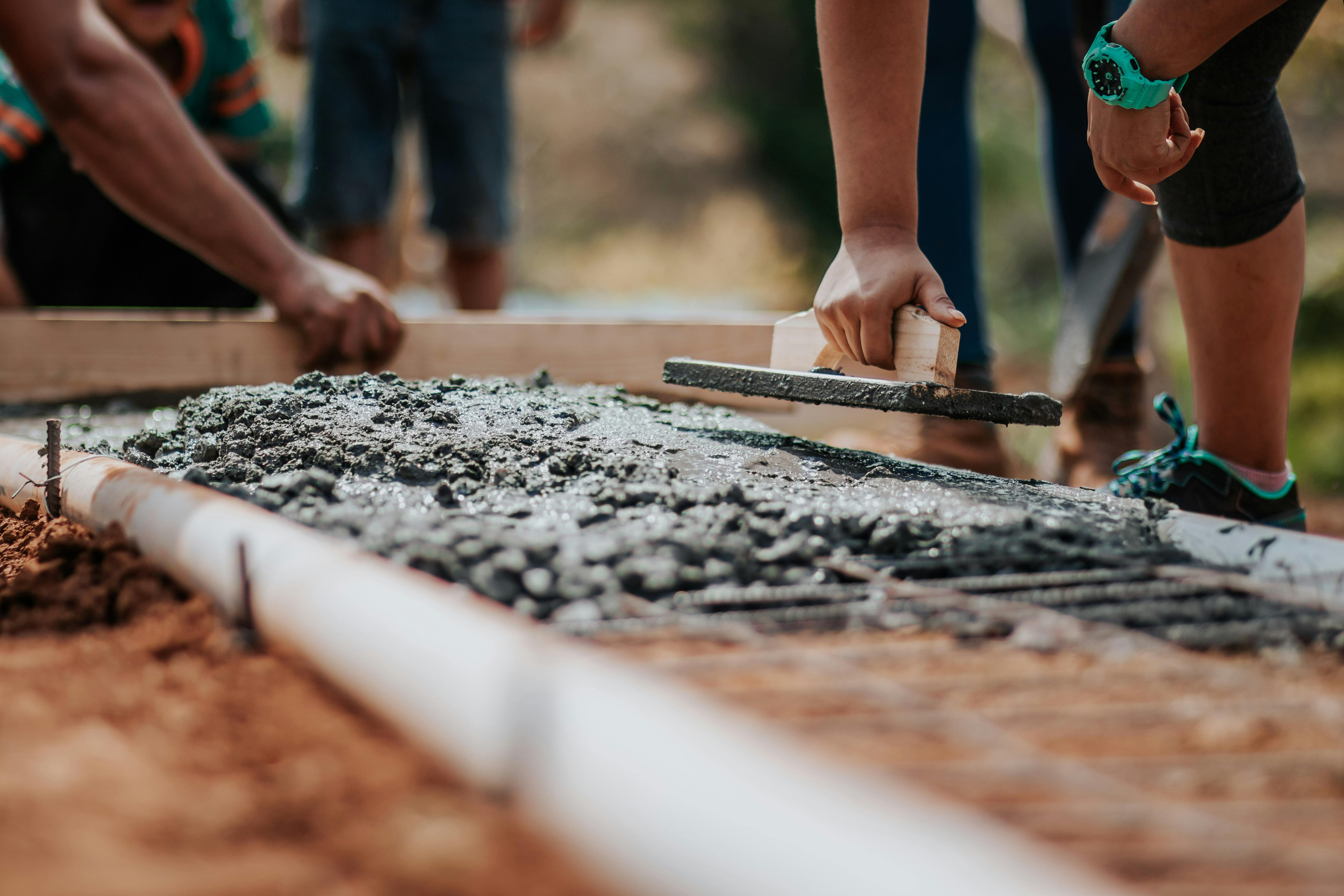 people rebuilding house and laying concrete