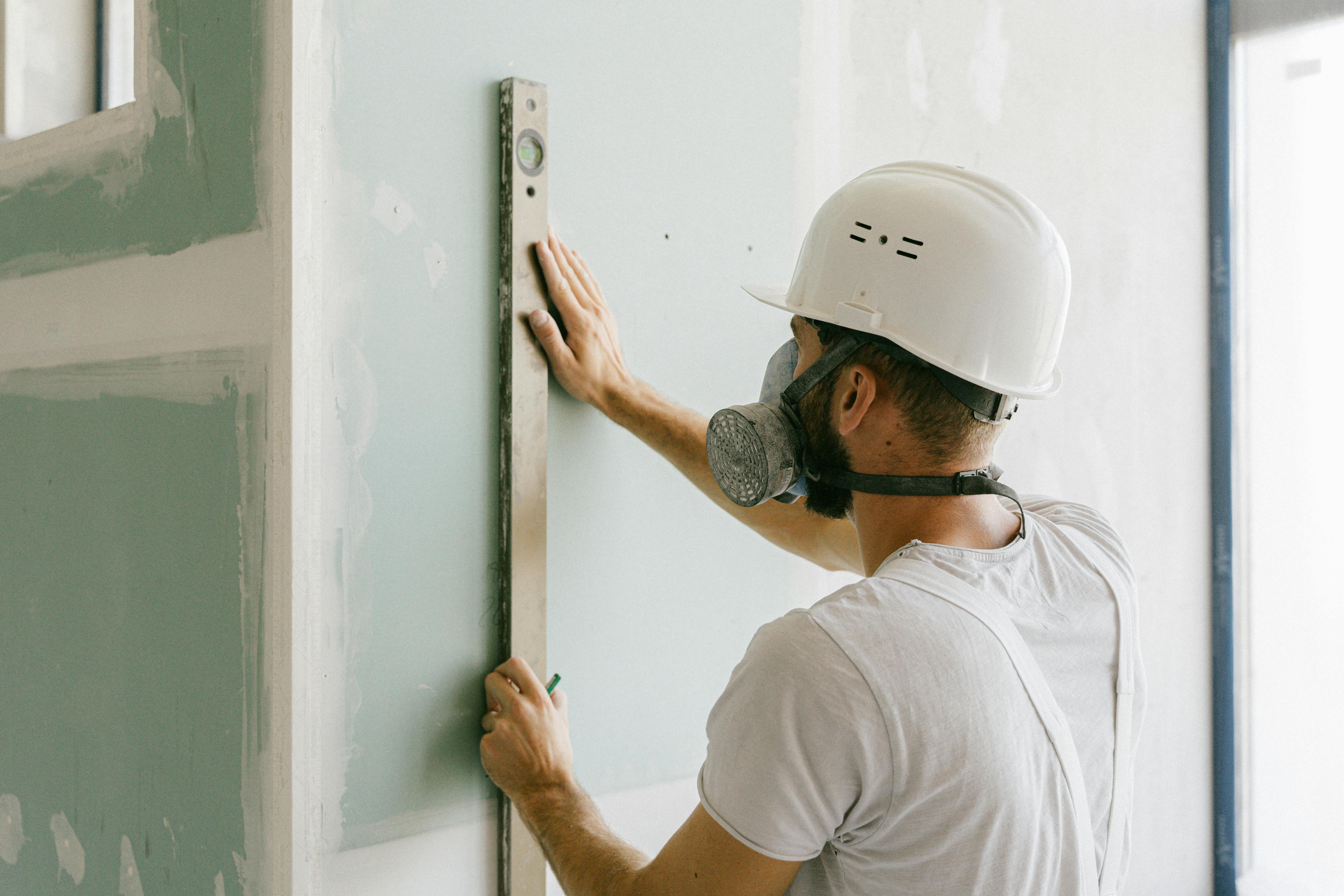 person measuring drywall